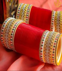 two bangles are sitting on top of each other in front of a red cloth