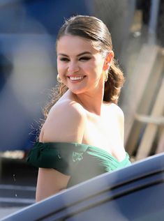 a woman in a green dress is smiling