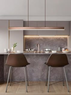 two brown chairs sitting in front of a kitchen counter