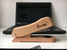 a laptop computer sitting on top of a desk next to a wooden stamper with the word remo written on it