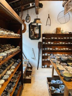 a room filled with lots of different types of plates and bowls on shelves next to each other