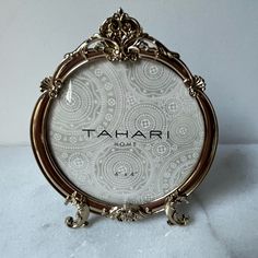 an ornate gold frame with the word tahari in arabic on it, sitting on a marble surface