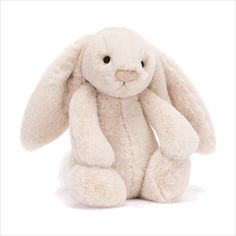 a white stuffed rabbit sitting up against a white background