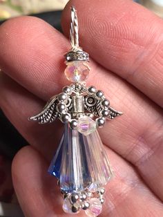 an angel charm is shown in the palm of someone's hand