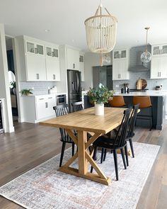 a wooden table sitting on top of a rug in a kitchen