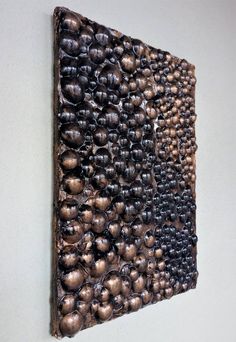 a piece of art that looks like it has been made out of wood and is hanging on the wall