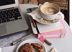 a white plate topped with fried food next to a cup of coffee and a laptop