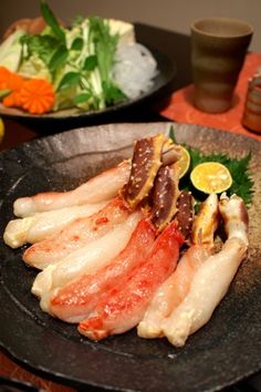 several pieces of raw fish on a black plate