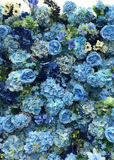 blue and white flowers are arranged in the shape of a large flower arrangement on display