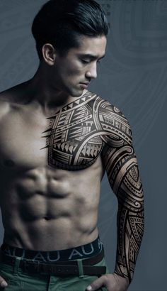 a man with a large tattoo on his chest and arm is posing for the camera