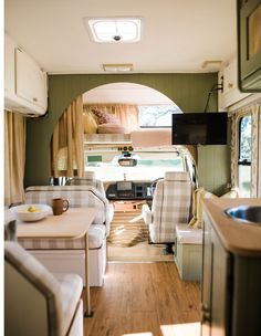 the inside of a camper with couches, tables and chairs in front of it