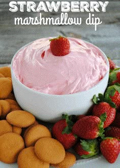 strawberry marshmallow dip in a white bowl surrounded by crackers and strawberries