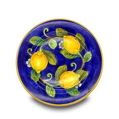 a blue and yellow plate with lemons painted on the side, sitting on a white surface