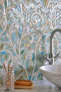 a faucet is shown in front of a wall with decorative tiles on it