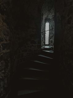 stairs leading up to an open window in a dark room