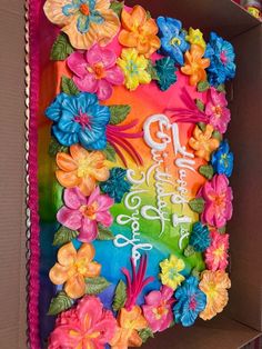 a birthday cake decorated with colorful flowers in a box for someone's special celebration