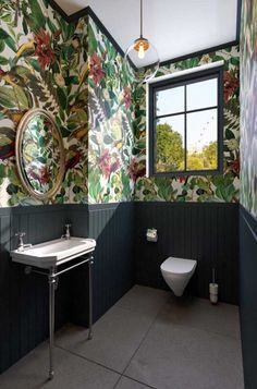 a bathroom with floral wallpaper and green walls