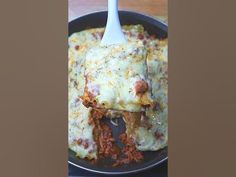 lasagna casserole with meat and cheese in a black pan on a wooden table