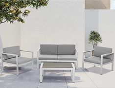 an outdoor seating area with two chairs and a coffee table in front of a white wall