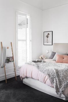 a bed with pink sheets and pillows in a bedroom next to a window, on instagram