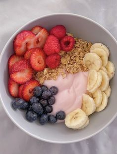 a bowl filled with fruit and yogurt on top of a white tablecloth