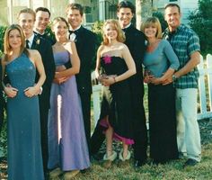 a group of people standing next to each other in front of a house