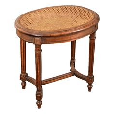 an oval wooden table with caned top