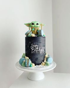 a star wars themed birthday cake with the baby yoda on top