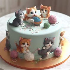 a cake decorated with kittens and balls of yarn