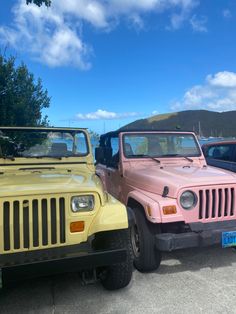 two pink and yellow jeeps parked next to each other