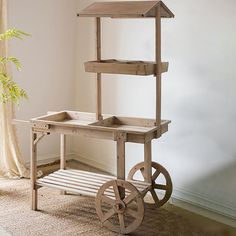 an old wooden cart with wheels and a birdhouse on it's top shelf