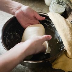 someone is kneading dough into a bowl