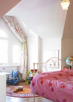 a bed room with a neatly made bed next to a window and a rug on the floor