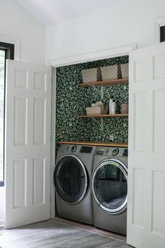 a washer and dryer in a room with green wallpaper on the walls