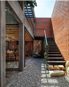 an outdoor area with stone steps, brick walls and stairs leading up to the second floor