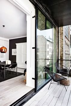 an open door leading to a balcony with black and white decor on the outside wall