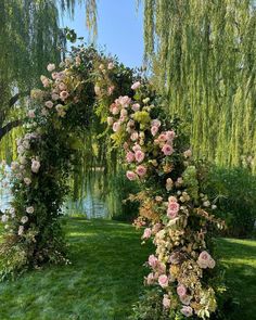 an arch made out of flowers in the grass