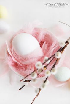 an egg is sitting on top of some feathers