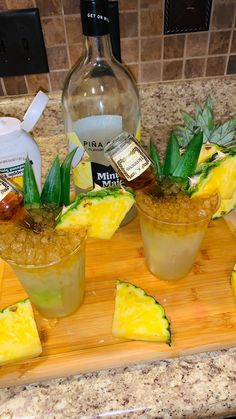 pineapple margaritas with garnishes on a cutting board