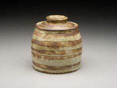 a brown and white striped jar with lid