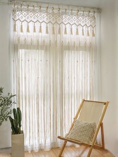 a chair sitting in front of a window next to a potted plant on top of a hard wood floor