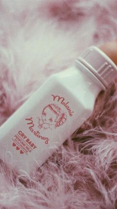 a bottle of baby milk sitting on top of some fur