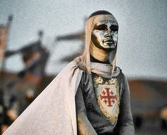 a statue with a cross on it's chest and a shield around its neck