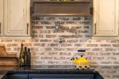 a yellow tea pot sitting on top of a kitchen counter next to a sink and oven