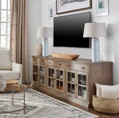 a living room with a large flat screen tv on top of a wooden entertainment center