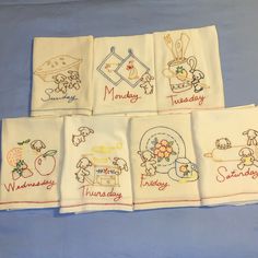 six embroidered napkins with different designs on them