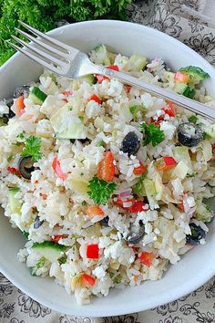 a white bowl filled with rice and veggies