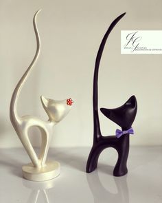 two black and white cat figurines sitting next to each other