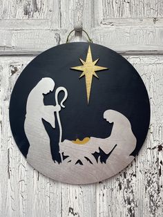 a metal ornament with a christmas nativity scene on it's side