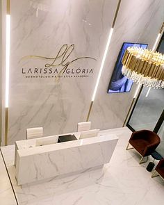 an elegant reception area with marble walls and flooring, chandelier and chairs